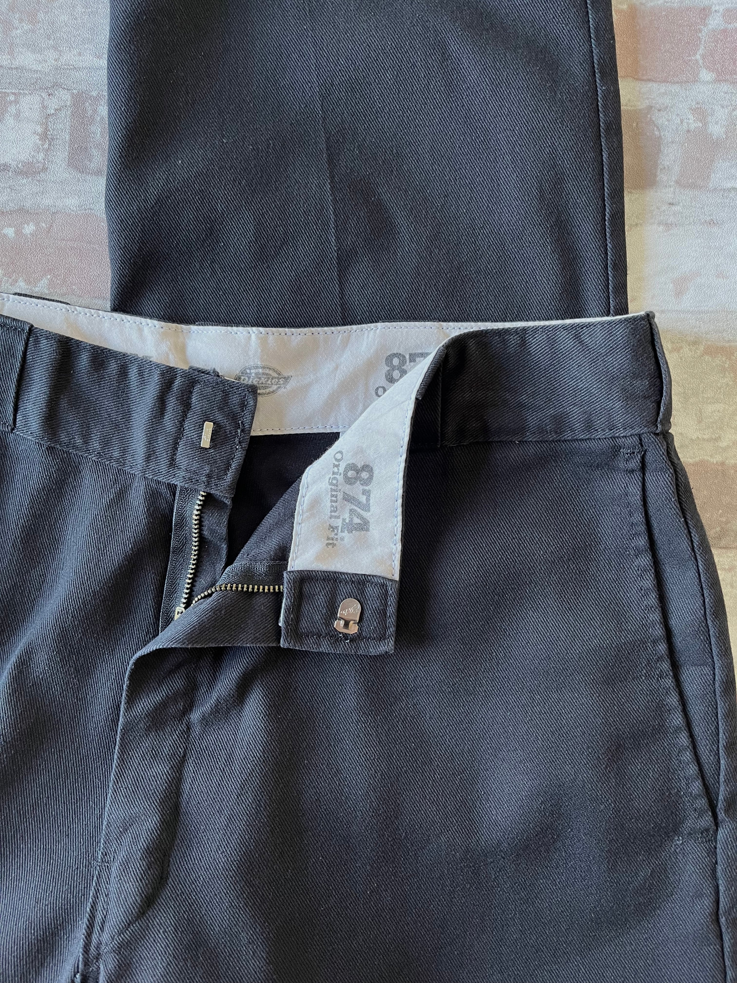 Pantalon de travail vintage Dickies 874 Original Fit noir délavé avec le patch logo Ox Collar à l'arrière, présenté plié à plat, détails ceinture et patine