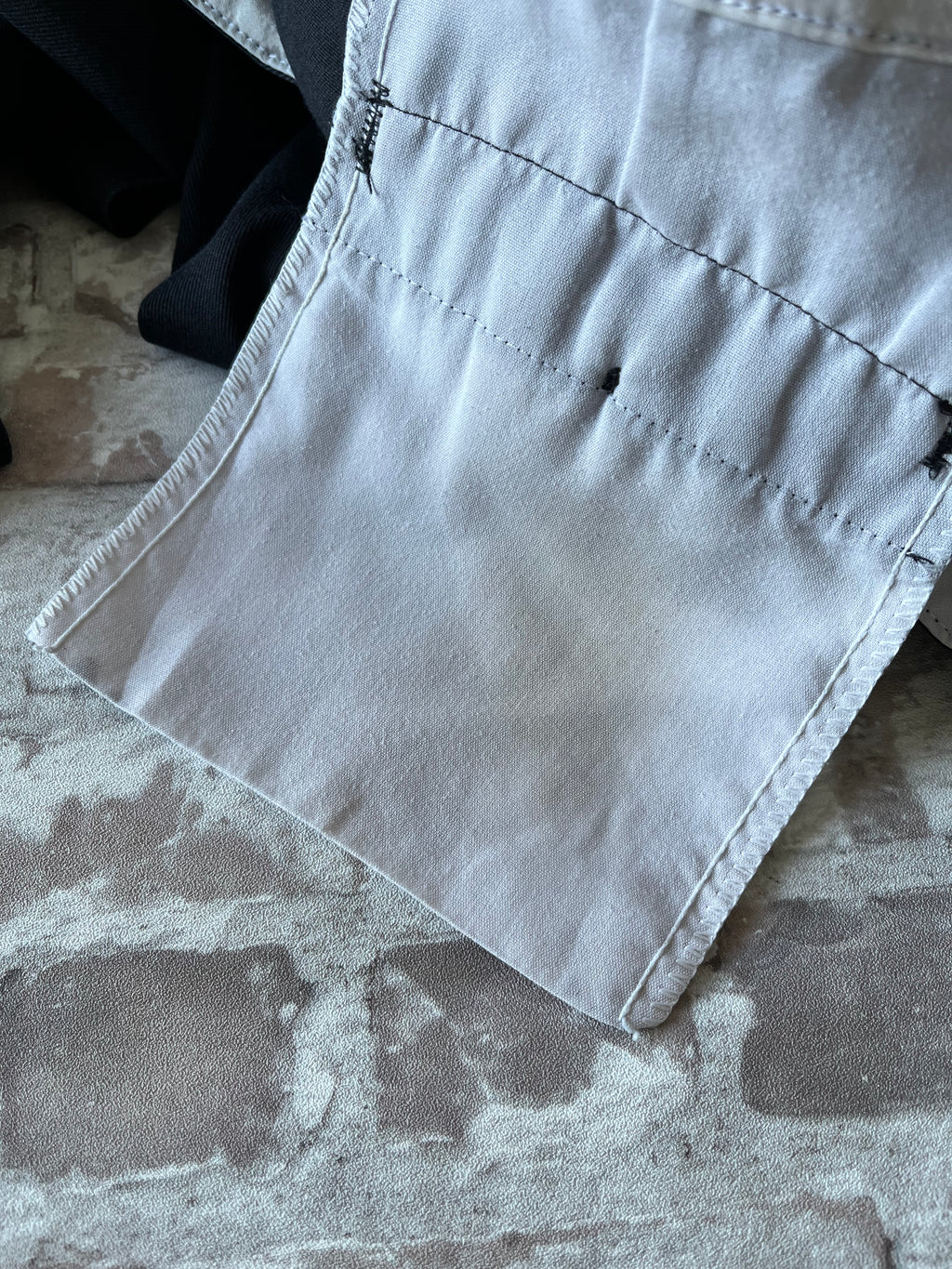 Gros plan sur les détails d'usure authentiques sur le tissu en twill d'un pantalon Dickies 874, tache rouille poche arrière intérieur.