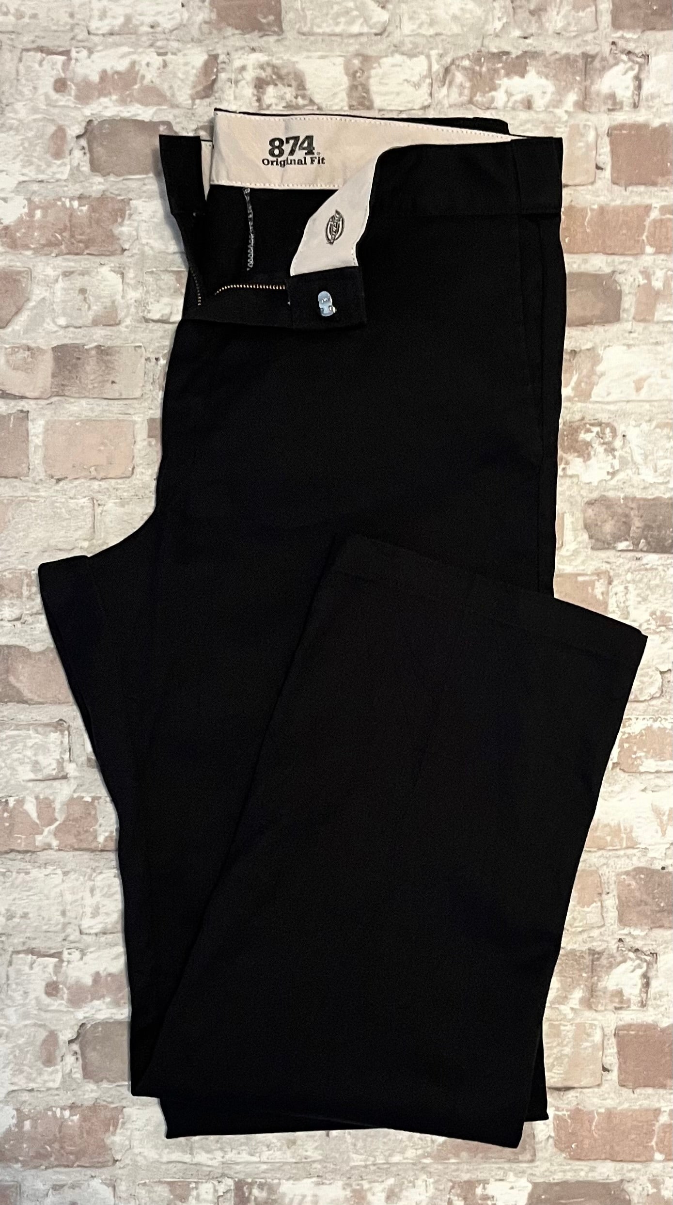 Pantalon de travail vintage Dickies 874 Original Fit couleur noir délavé anthracite avec patch tissé Ox Collar à l'arrière, présenté plié à plat.