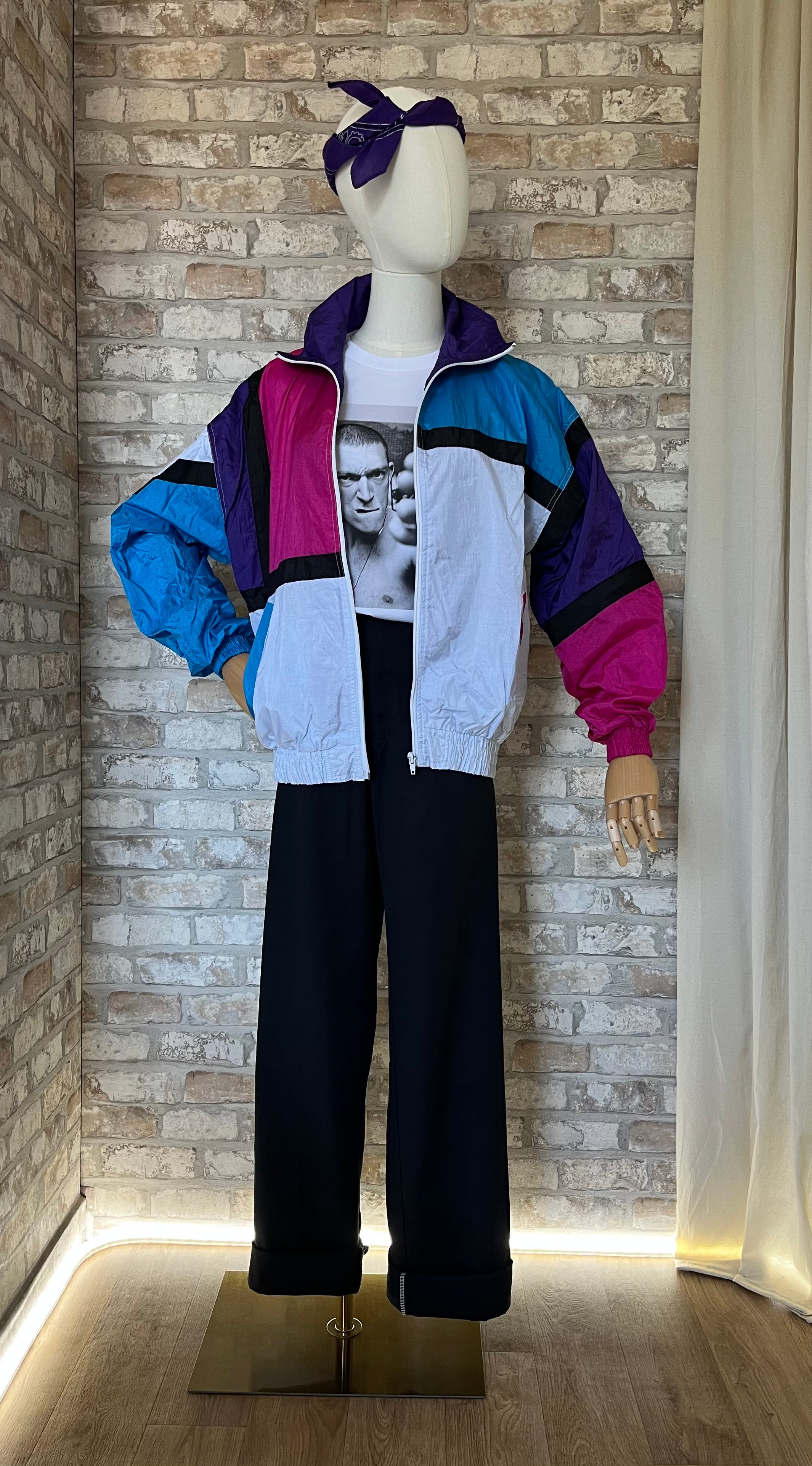 Veste colorblock vintage Blair Boutique turquoise et rose portée avec un pantalon Dickies 874 noir, un t-shirt blanc imprimé "La Haine" et un bandana sur la tête.
