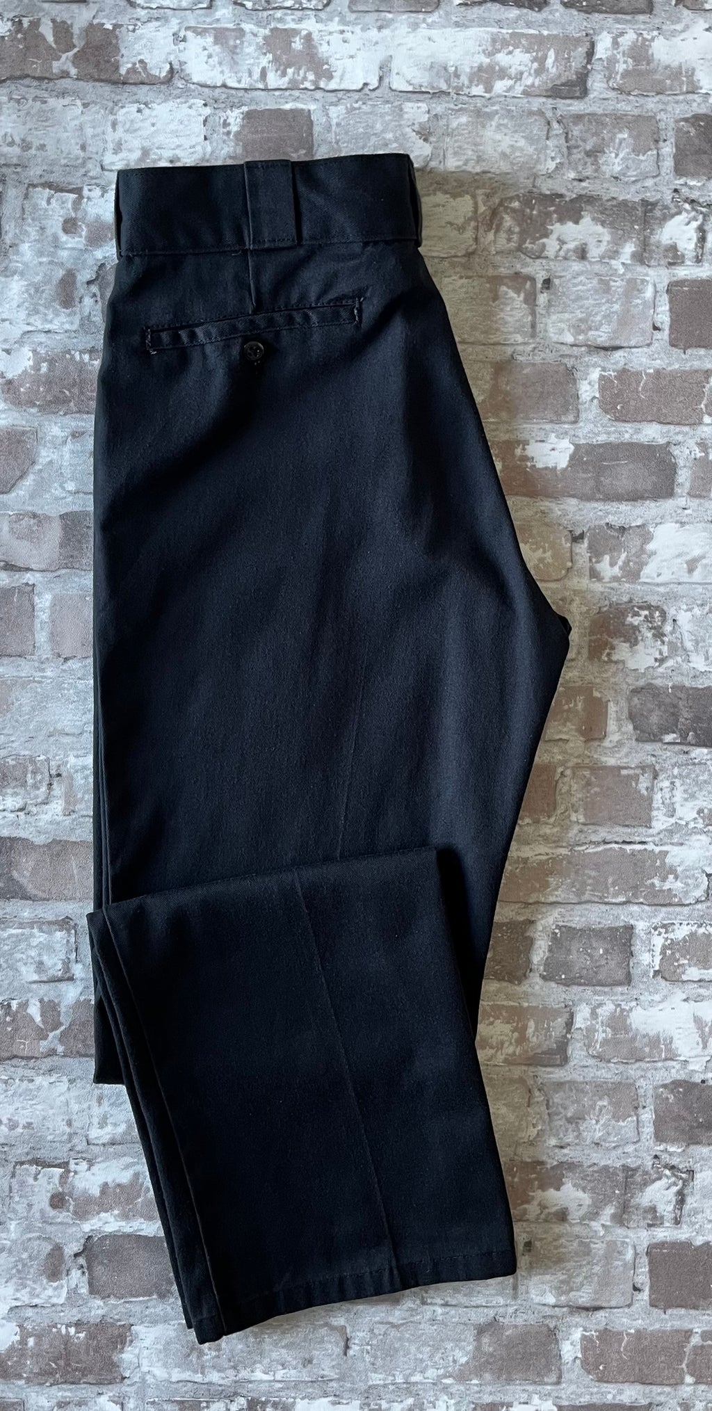 Pantalon de travail vintage Dickies 874 Original Fit noir avec pli permanent et patch logo à l'arrière, présenté plié à plat.