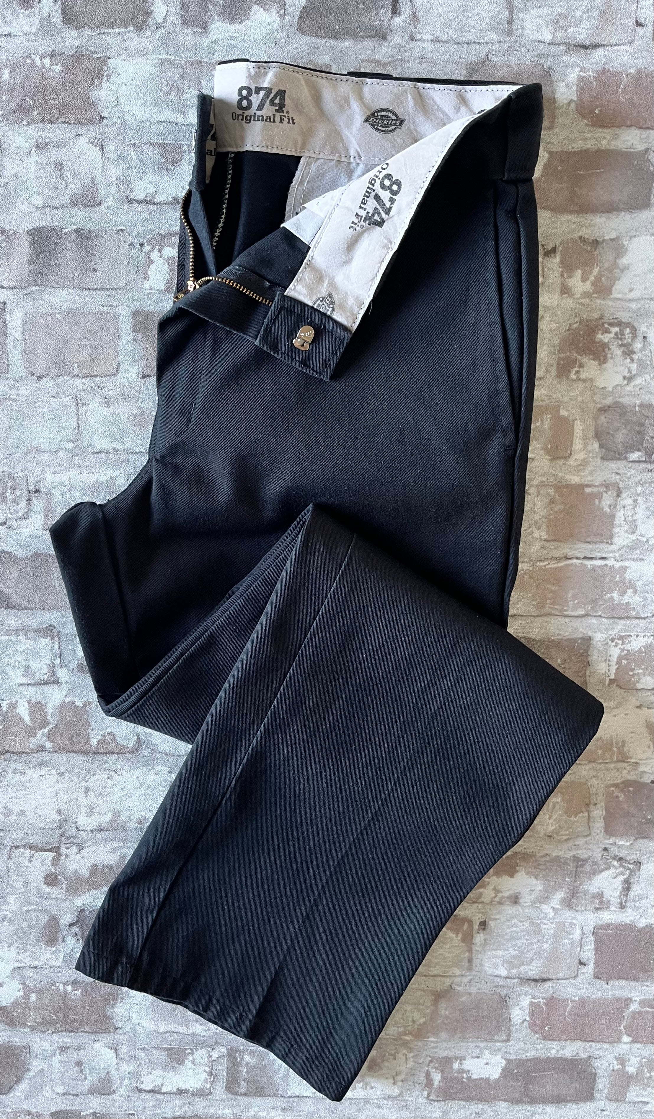 Pantalon de travail vintage Dickies 874 Original Fit noir avec pli permanent et patch logo à l'arrière, présenté plié à plat.