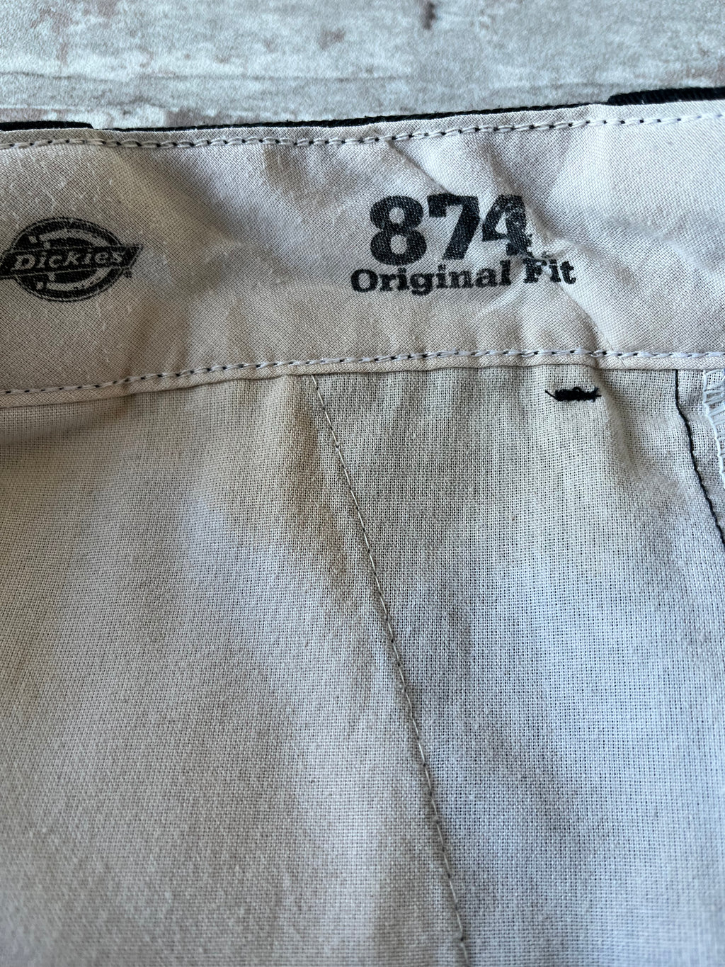 Gros plan sur la tache de rouille à l'intérieur de la ceinture d'un pantalon vintage Dickies 874 noir.