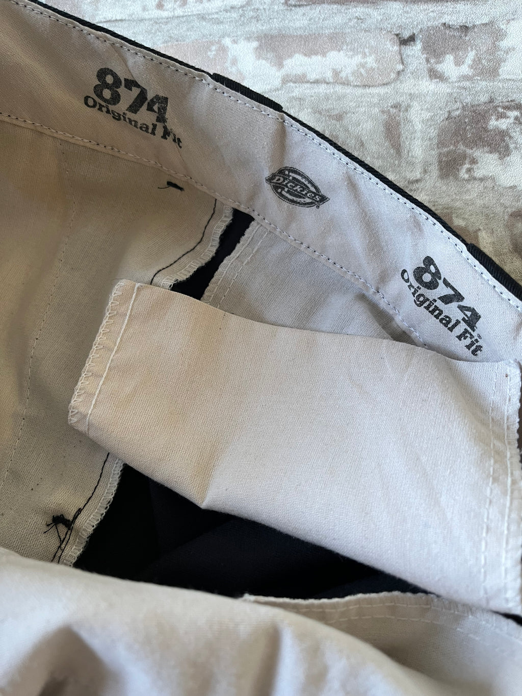 Gros plan sur la tache de rouille à l'intérieur de la ceinture d'un pantalon vintage Dickies 874 noir.