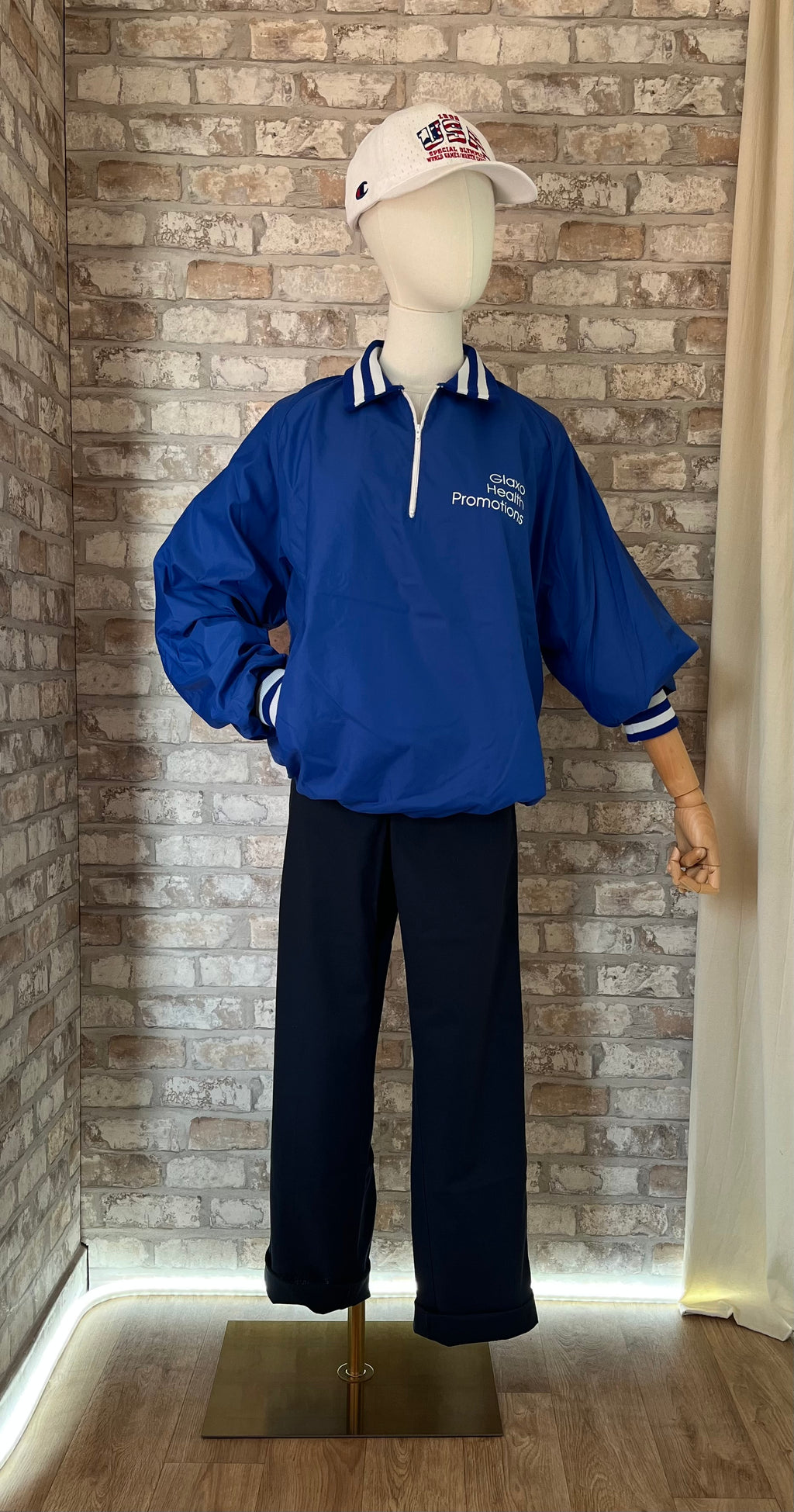 Windshirt vintage bleu roi Glaxo porté avec un pantalon Dickies slim bleu nuit, une casquette Champion rétro et des patchs La Barbuda.