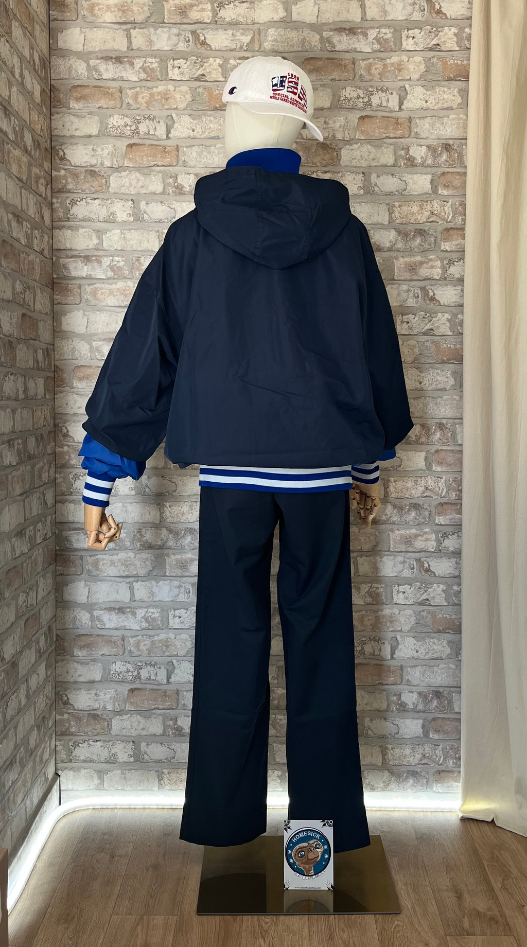 Anorak vintage Champion bleu marine au logo patiné porté avec un pantalon Dickies bleu nuit et un patch La Barbuda, de dos