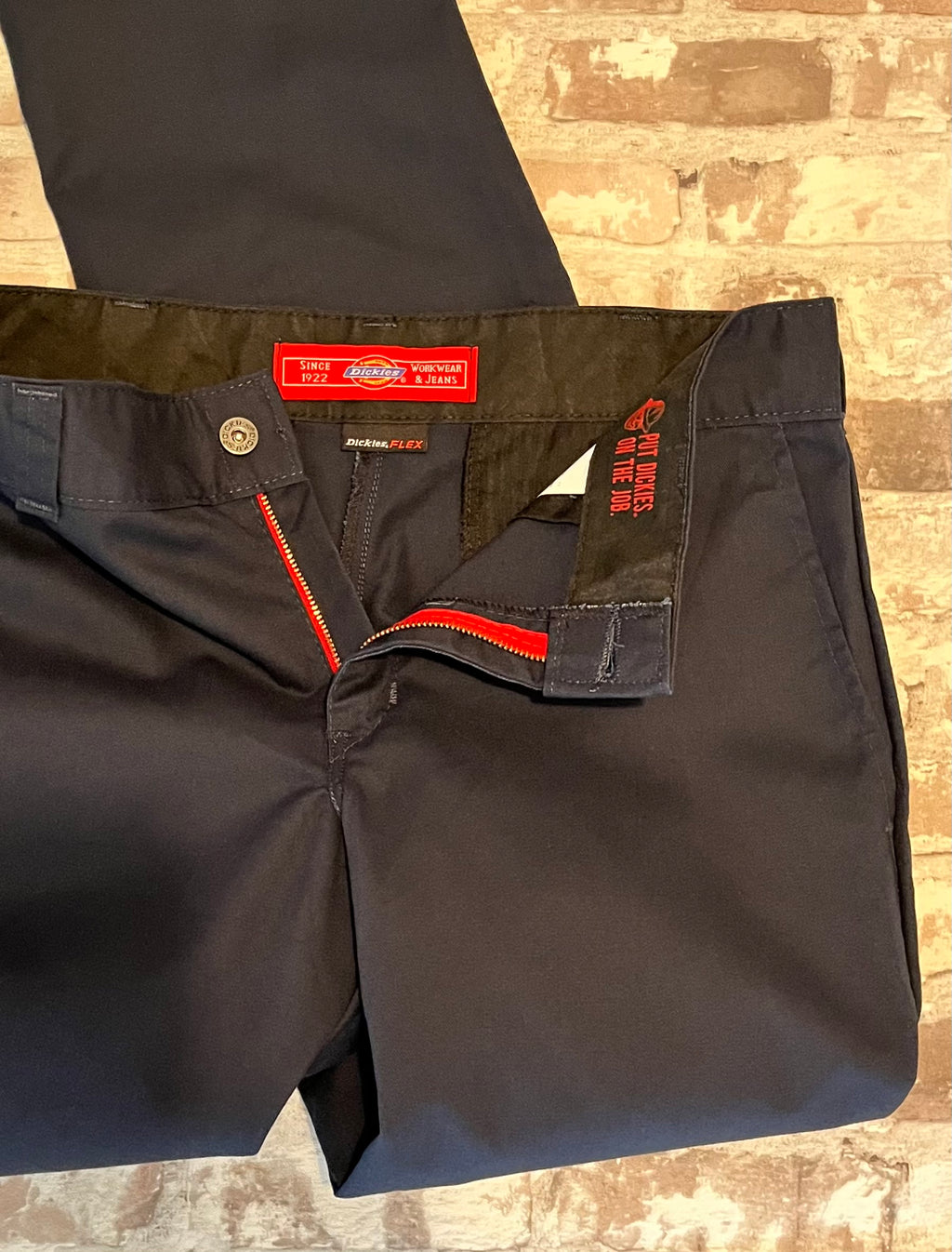 Pantalon coupe slim bleu nuit Dickies Flex avec pli central permanent, présenté à plat , détails rouge