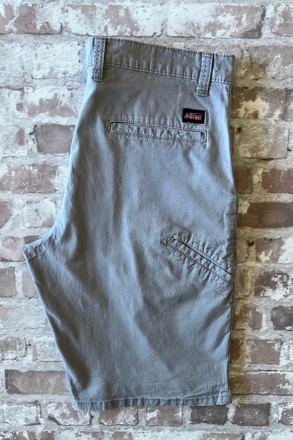 Short technique gris graphite Dickies Ripstop Flex à découpe de poches ergonomique, présenté à plat 