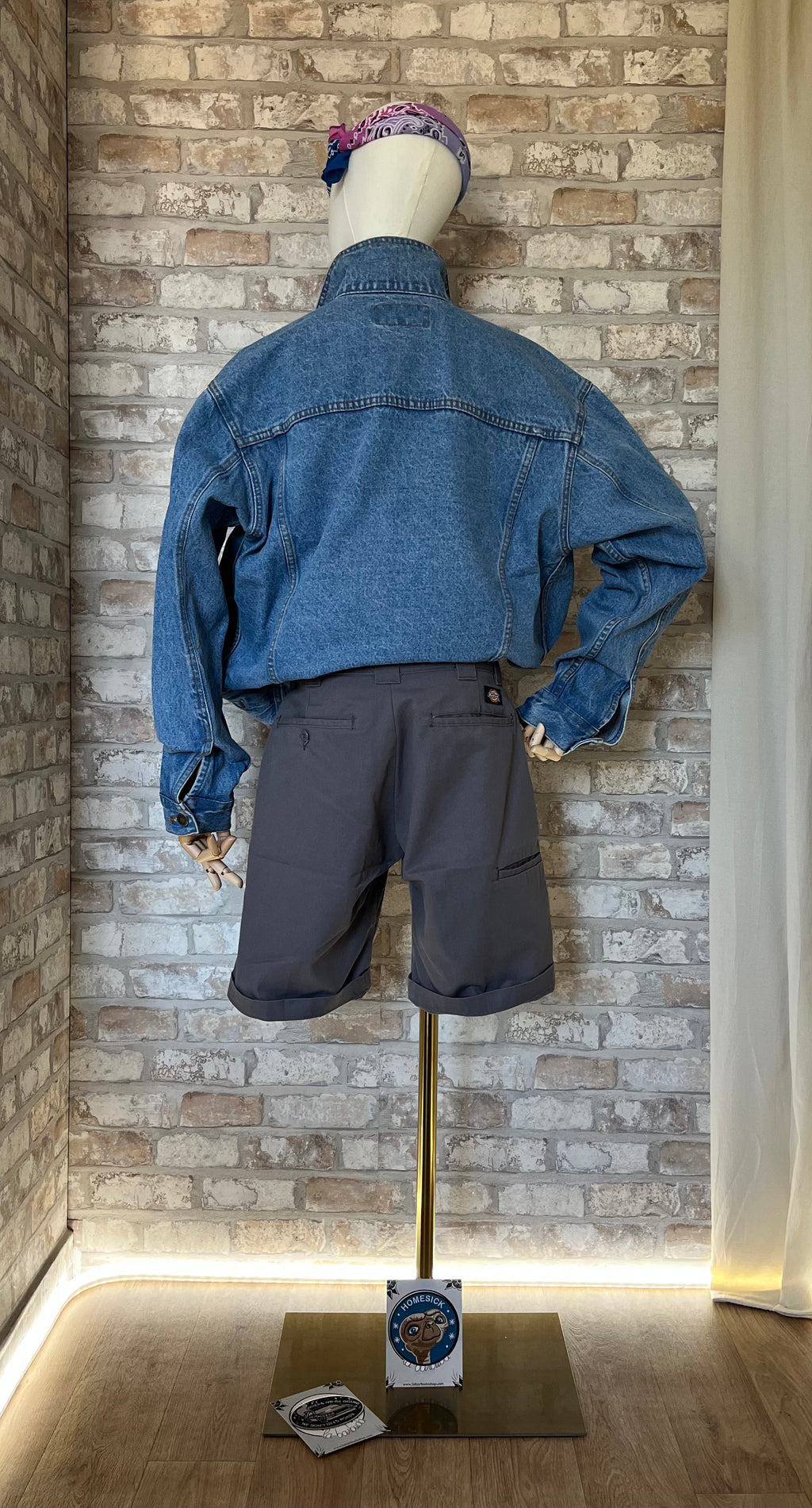 Vue de dos d'un short Dickies anthracite porté avec une veste sans manches customisée de patchs La Barbuda.