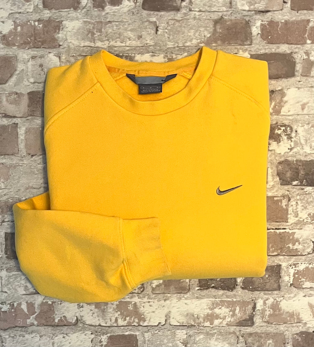 Sweat col rond vintage Nike jaune vif avec le logo Swoosh brodé sur la poitrine, présenté plié à plat.