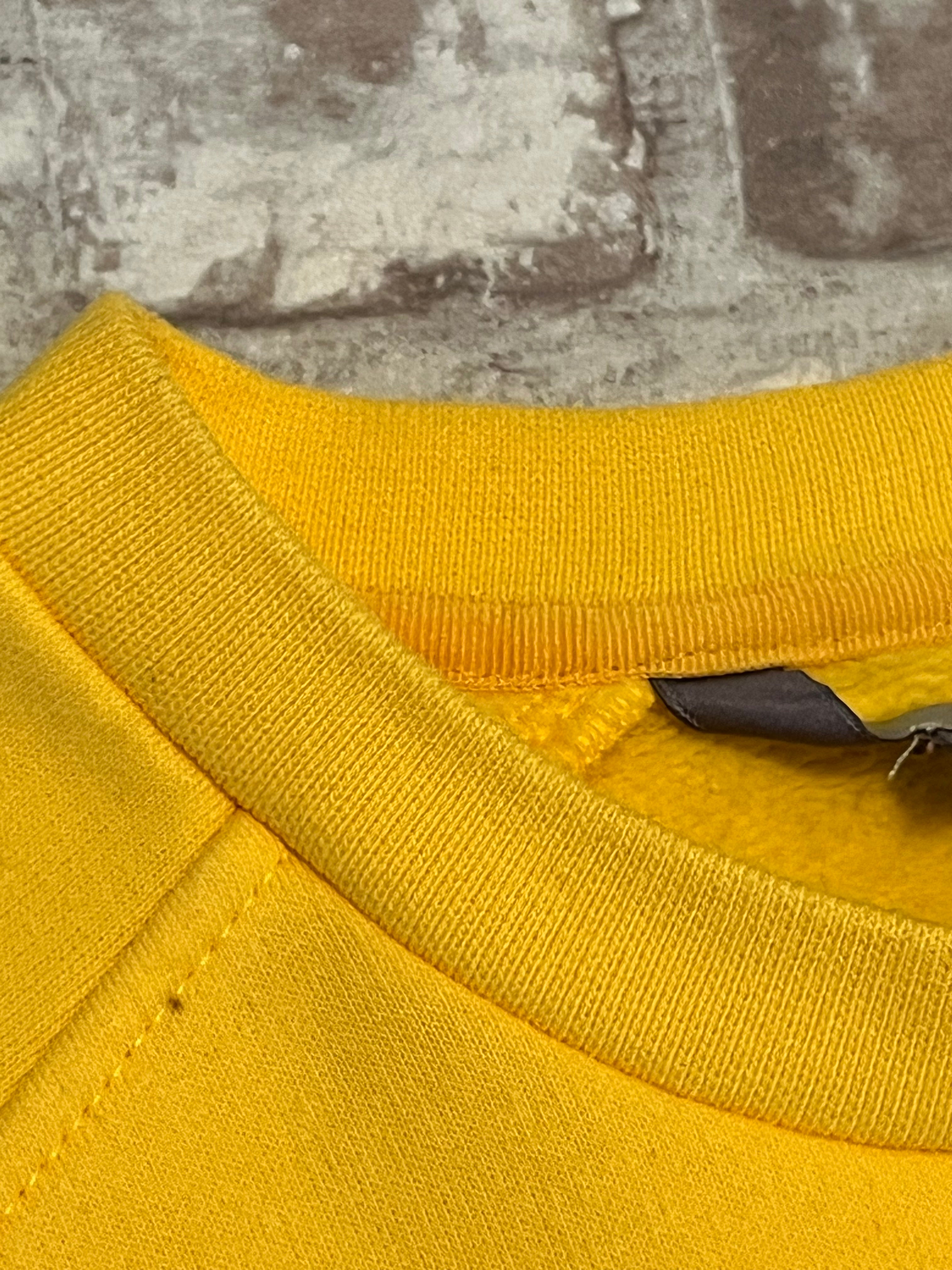 Sweat col rond vintage Nike jaune vif avec le logo Swoosh brodé sur la poitrine, présenté à plat, focus col et point noir