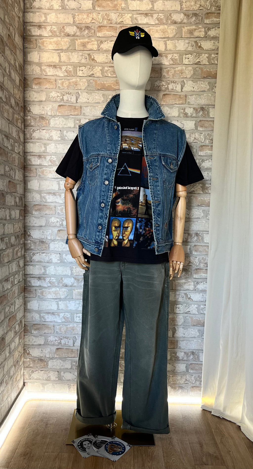 T-Shirt Anthill Rockware - Pink Floyd avec un pantalon Carhartt, une veste en jean sans manches Tommy Hilfiger, une casquette Grafitee Goldorak porté par un mannequin de face et des Patchs La Barbuda posés au sol.