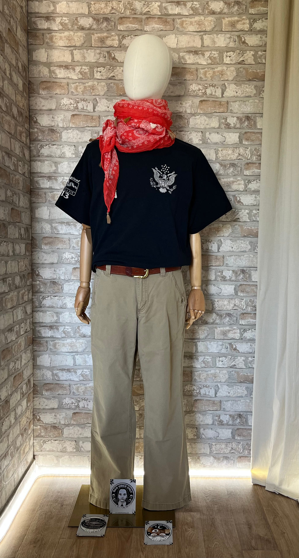 T-Shirt Gildan, Moreschi Illustration, porté de face sur un mannequin avec un Pantalon Carhartt, une ceinture Vintage en cuir, un cheich IKKS mandarine et au sol des Patchs La Barbuda