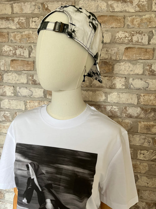 Casquette Adidas Originals tie-dye noire et blanche portée avec un t-shirt blanc au motif de nonne sur un skate et des boucles d'oreilles Les Bijoux de Sophie.