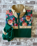 Coupe-vent en nylon vintage On Your Mark au motif floral rétro et coloris vert forêt, présenté plié à plat.