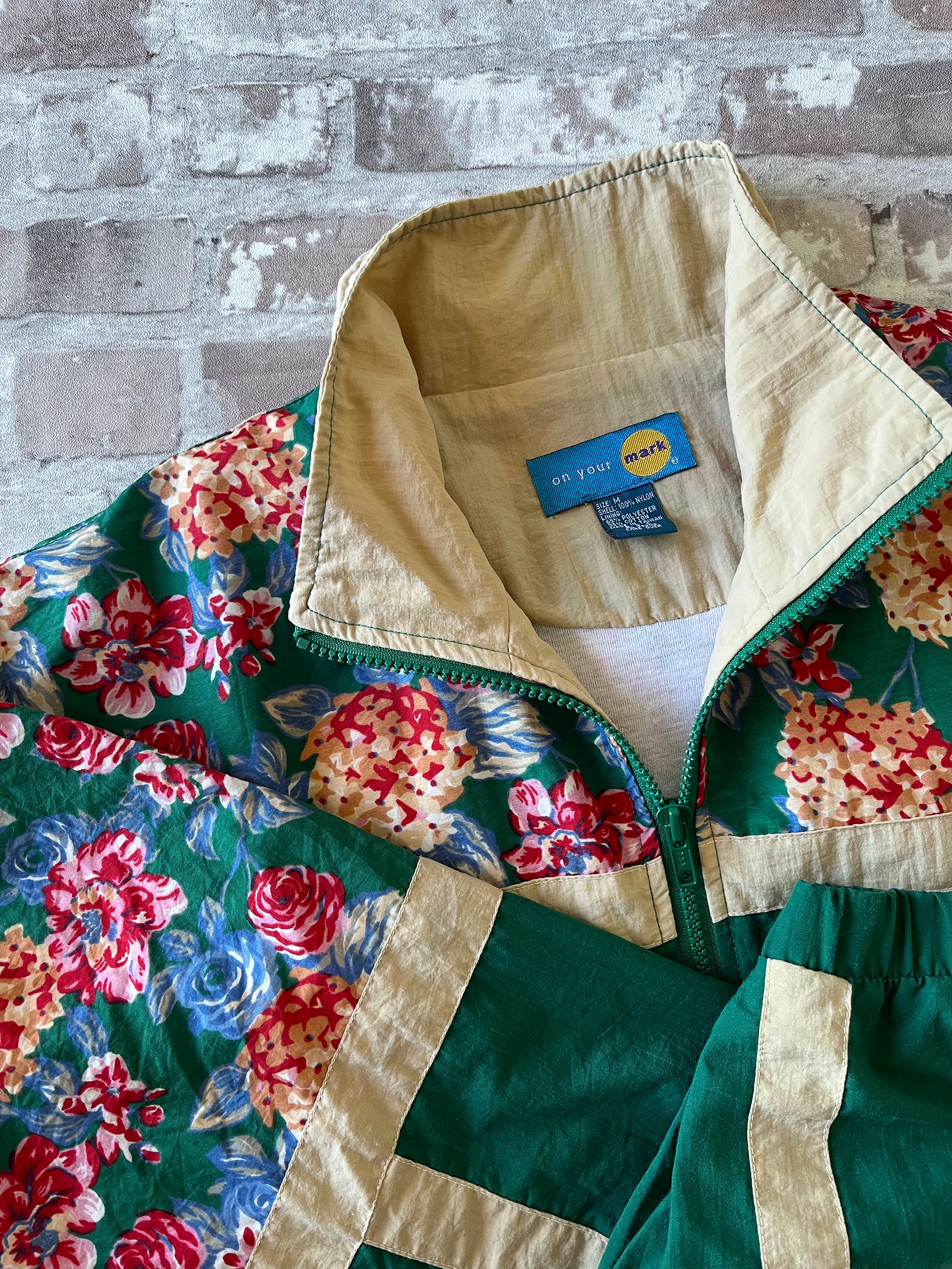 Veste coupe-vent vintage des années 90 couleur vert sapin avec empiècements à motifs de fleurs et bandes beiges, présentée à plat, focus col