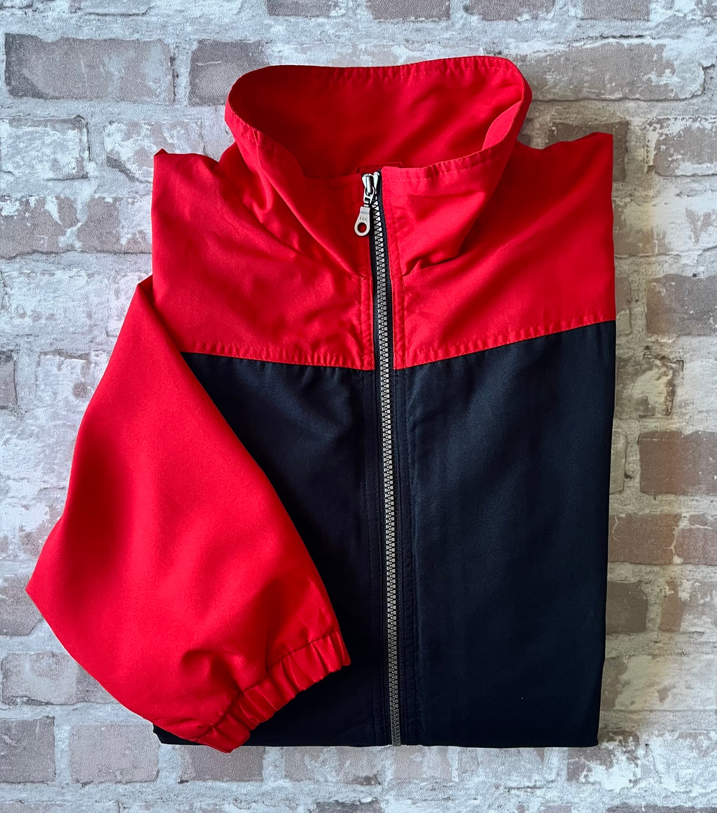 Veste de sport technique vintage de la marque canadienne Kobe Sportswear au design colorblock rouge, noir et blanc, présentée à plat, pliée