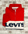 Coupe-vent vintage Levi's tricolore bleu marine, blanc et rouge avec grand logo sérigraphié sur la poitrine, présenté plié à plat.