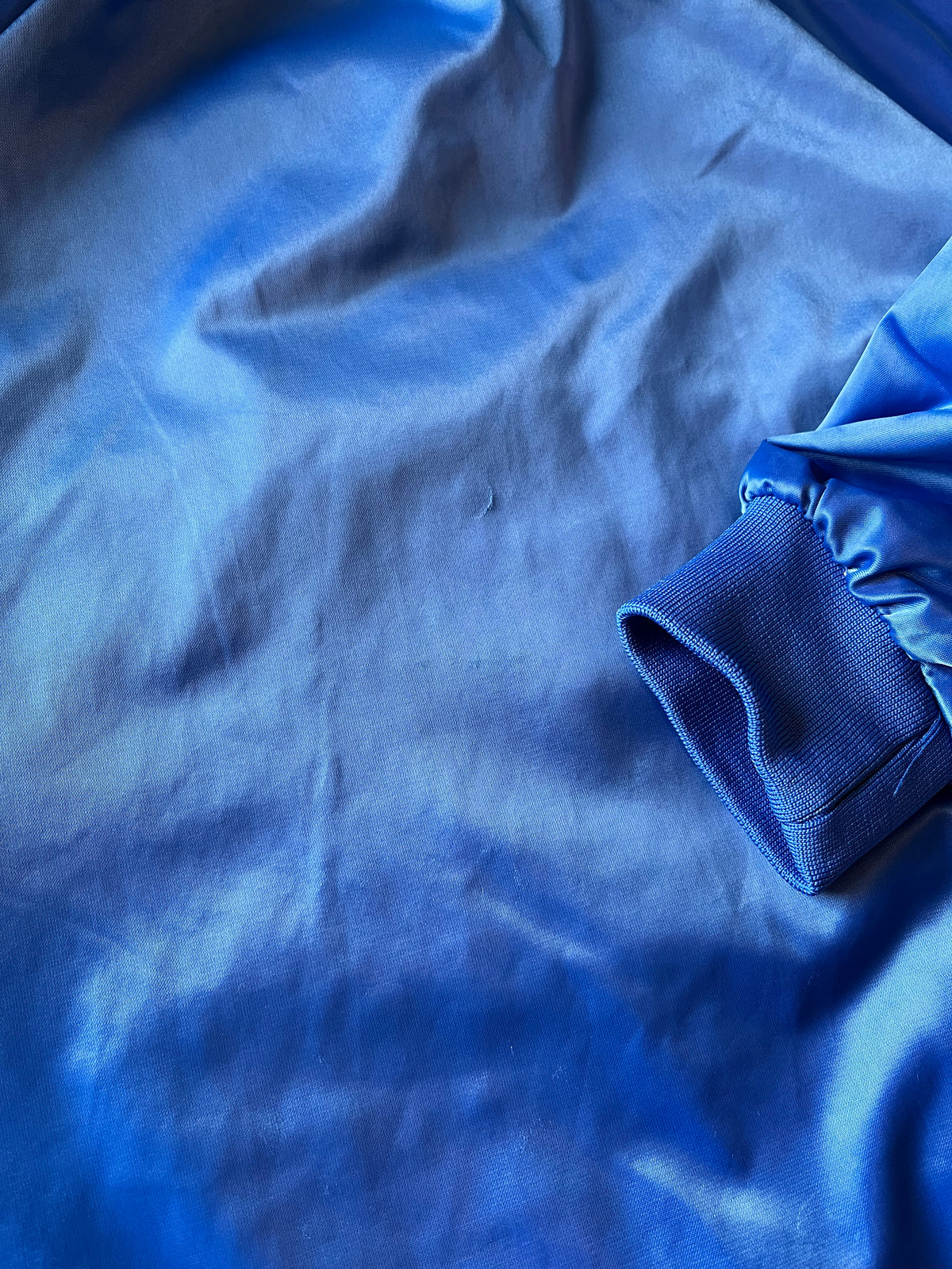 Veste de sport bomber léger rétro Cardinal bleu satiné avec fermeture à boutons-pression et écusson Campers On Mission, présentée à plat, focus marques au dos. Idéale à personnaliser avec nos patchs thermocollants.