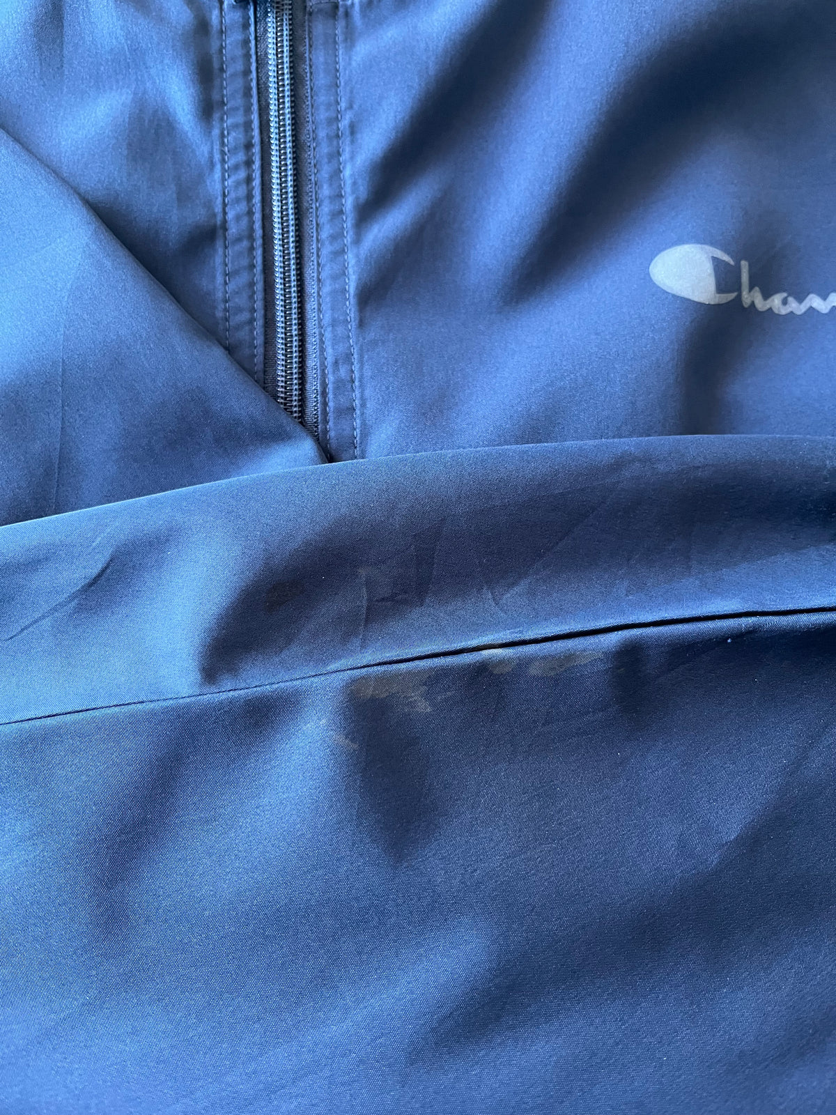 Veste coupe-vent anorak vintage Champion bleu marine avec demi-zip et poche kangourou, focus taches