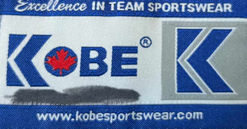 Veste vintage Kobe Sportswear rouge et noire , focus trace marqueur sur étiquette marque