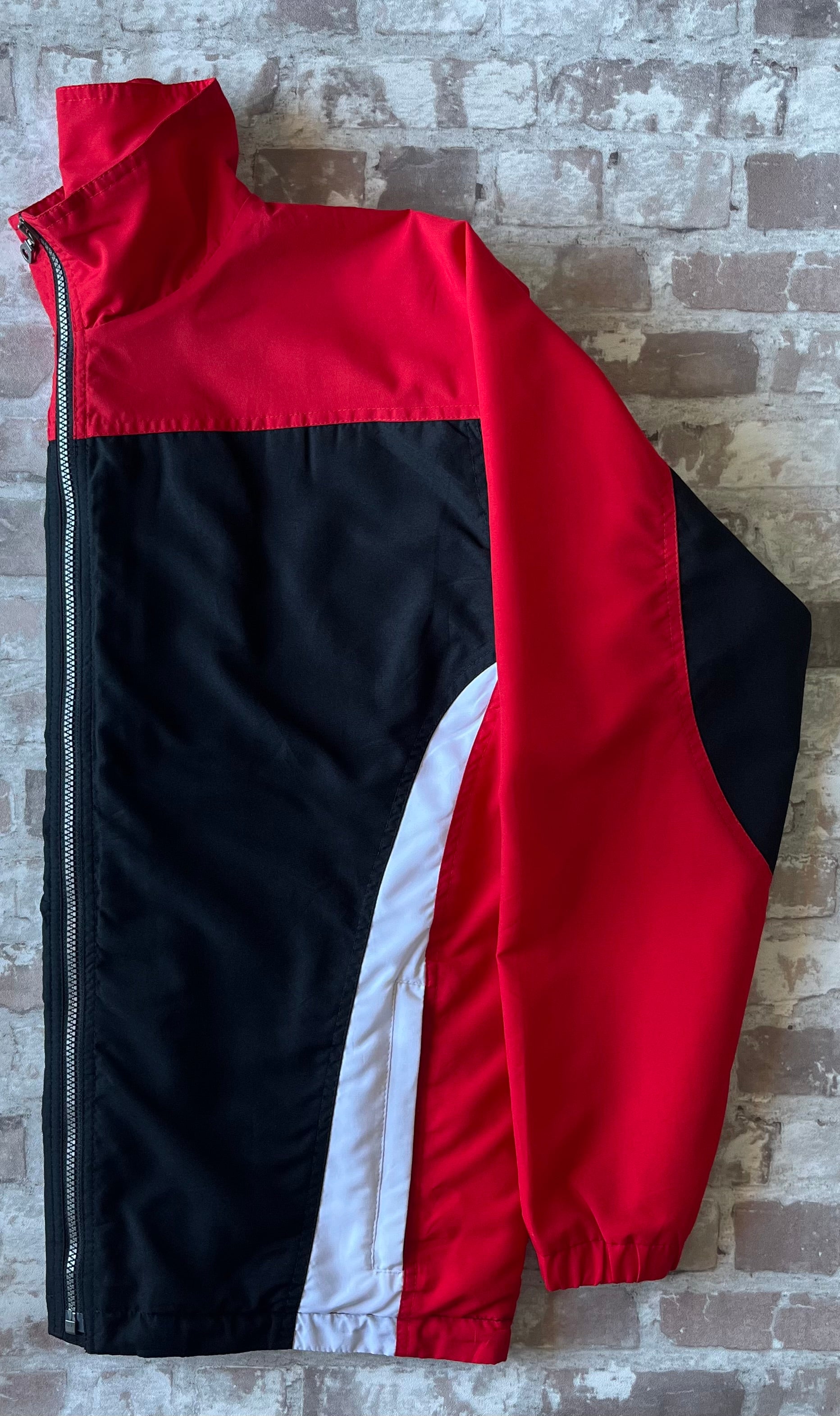 Veste de sport technique vintage de la marque canadienne Kobe Sportswear au design colorblock rouge, noir et blanc, présentée à plat.