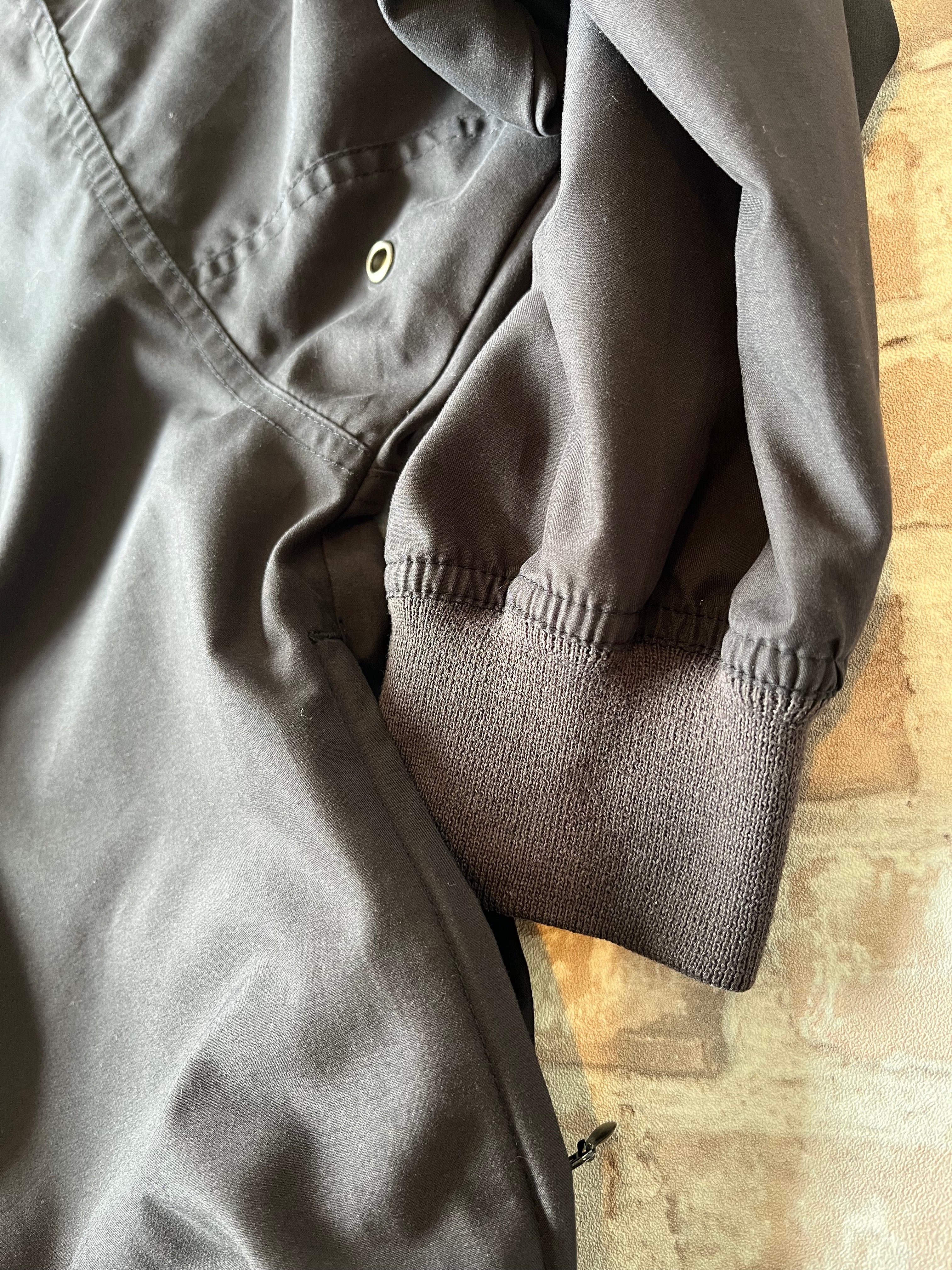 Veste de sport pullover vintage LA Loving noire au toucher peau de pêche avec broderie Buffalo et col en V marron, présentée à plat. 